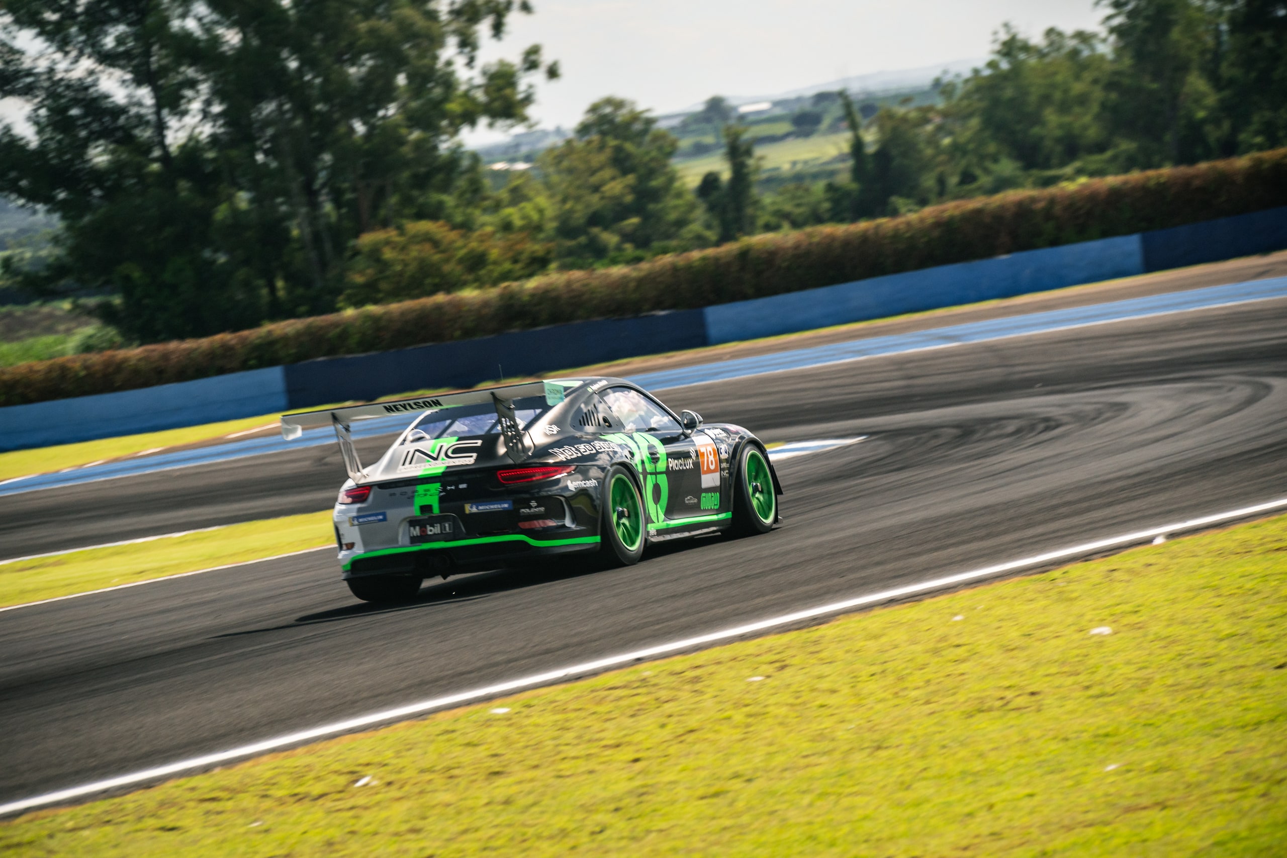 Porsche #78 saindo da curva — INC e NEYLSON visíveis na traseira